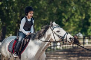 Kind leert paardrijden met paardrijkleding